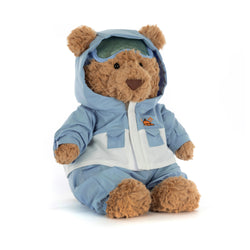 Stuffed teddy bear wearing a blue snowsuit with goggles on a white background